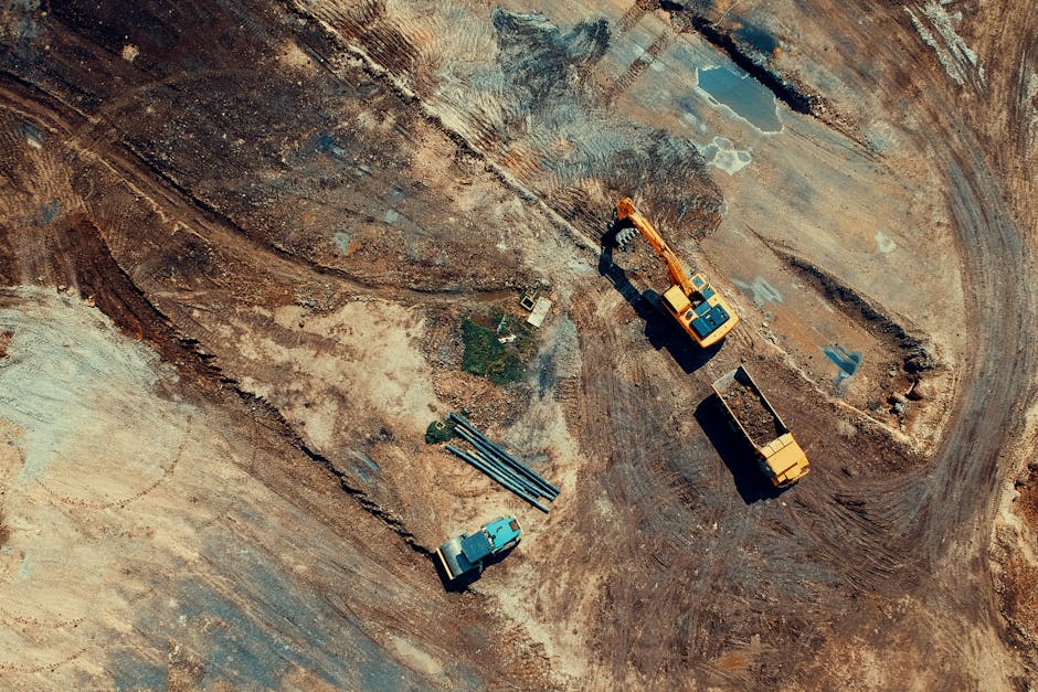 Aerial view of a construction site featuring heavy machinery and trucks, displaying industrial activity.